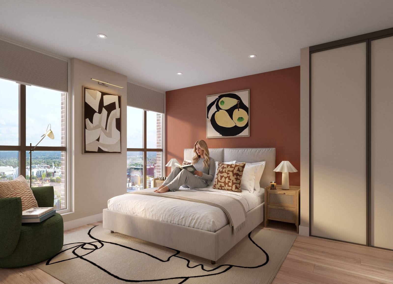 A bedroom with a large bed, terracotta feature wall and city views, with a woman reading on the bed